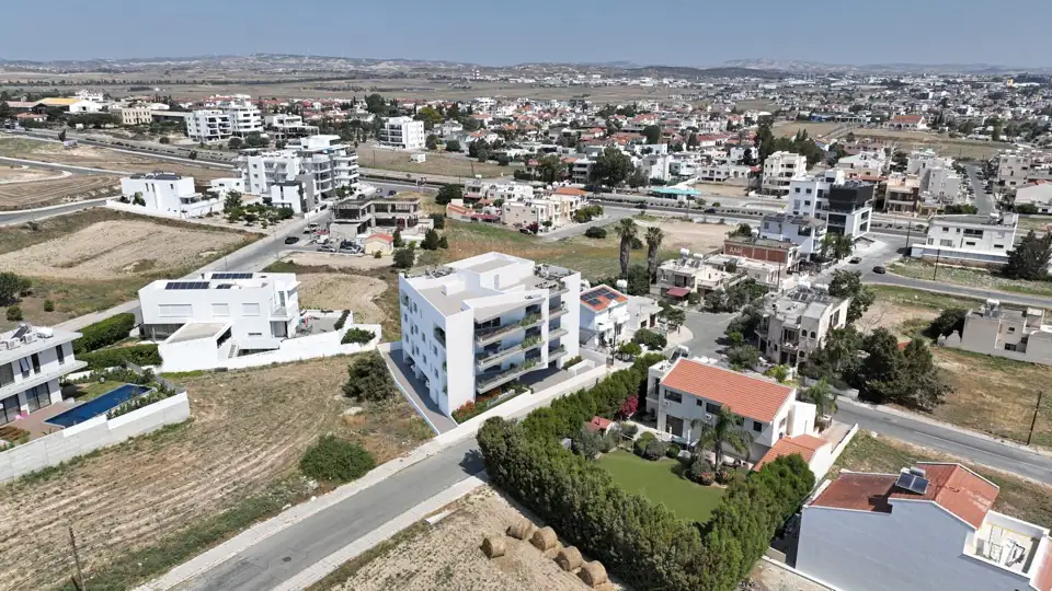 Aerial photograph of the completed white block among suburban housing and open plots
